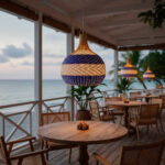 Terraza de restaurante en el mar con 3 lámparas de ratán de color azul y blanco modelo Brava